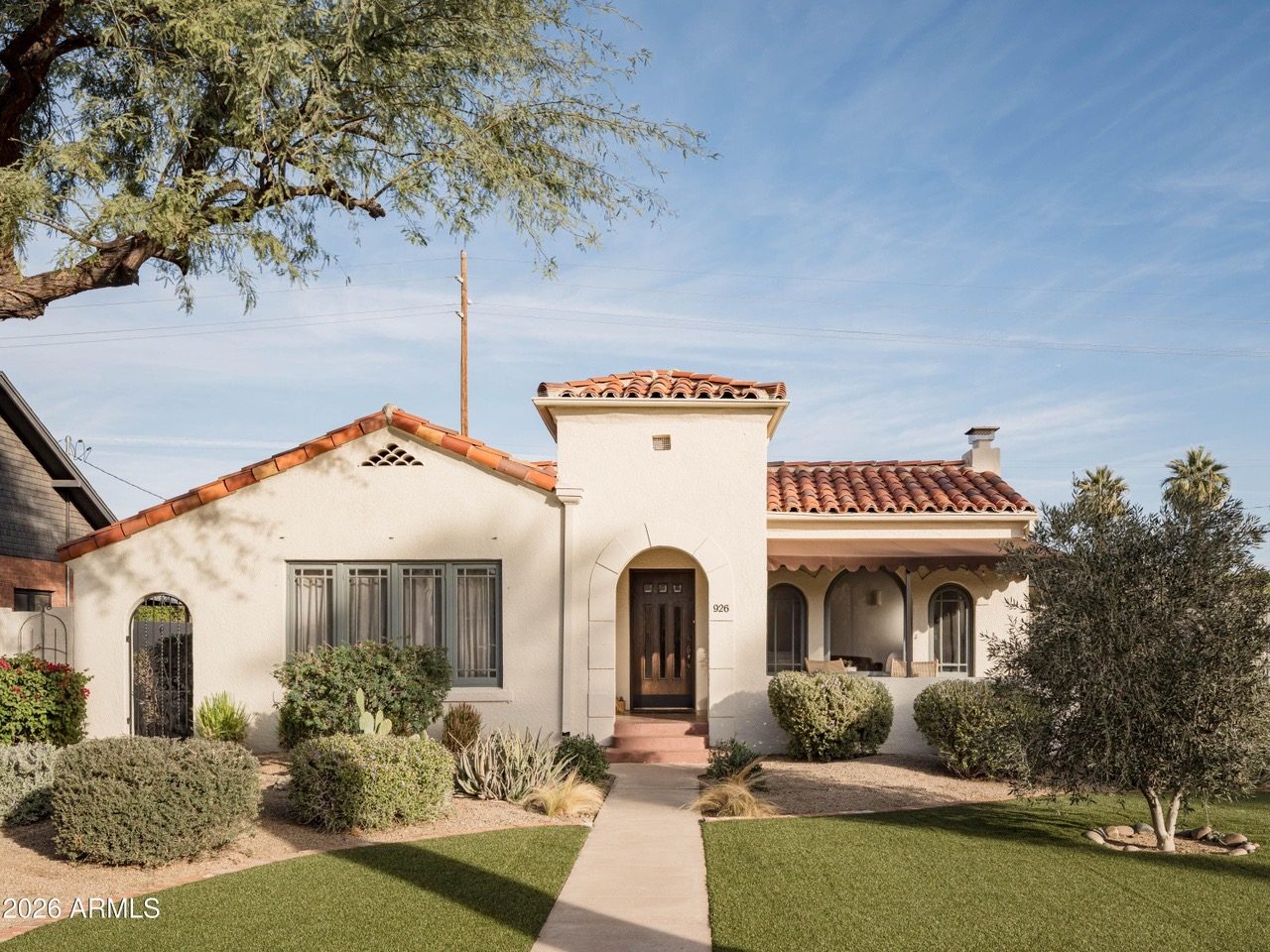 Covered arched porch with rattan chairs — Arizona Spanish Revival